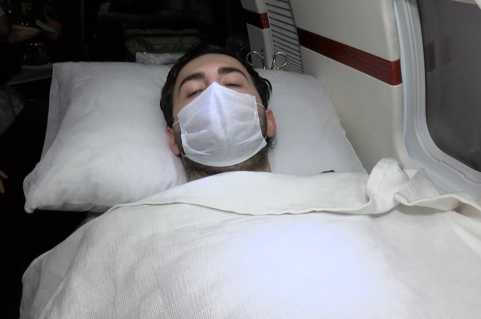 Haluk Hasan Seyithanoğlu, 24, lies on a bed inside the plane provided by the Turkish Health Ministry to take the student back to Turkey, April 27, 2020. (DHA Photo)