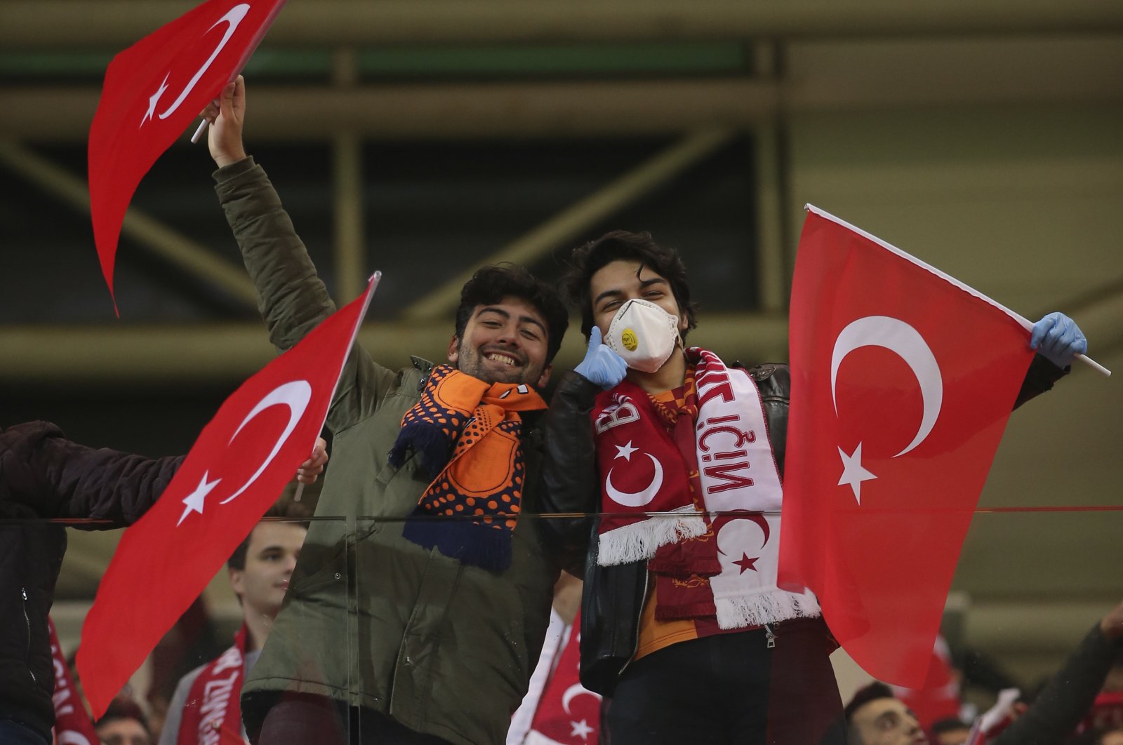 Spectators, some wearing masks because of the coronavirus outbreak, wave Turkish flags prior to the first leg of a Europa League top 16 soccer match between Başakşehir and Copenhagen, in Istanbul, March 12, 2020. (AP Photo)