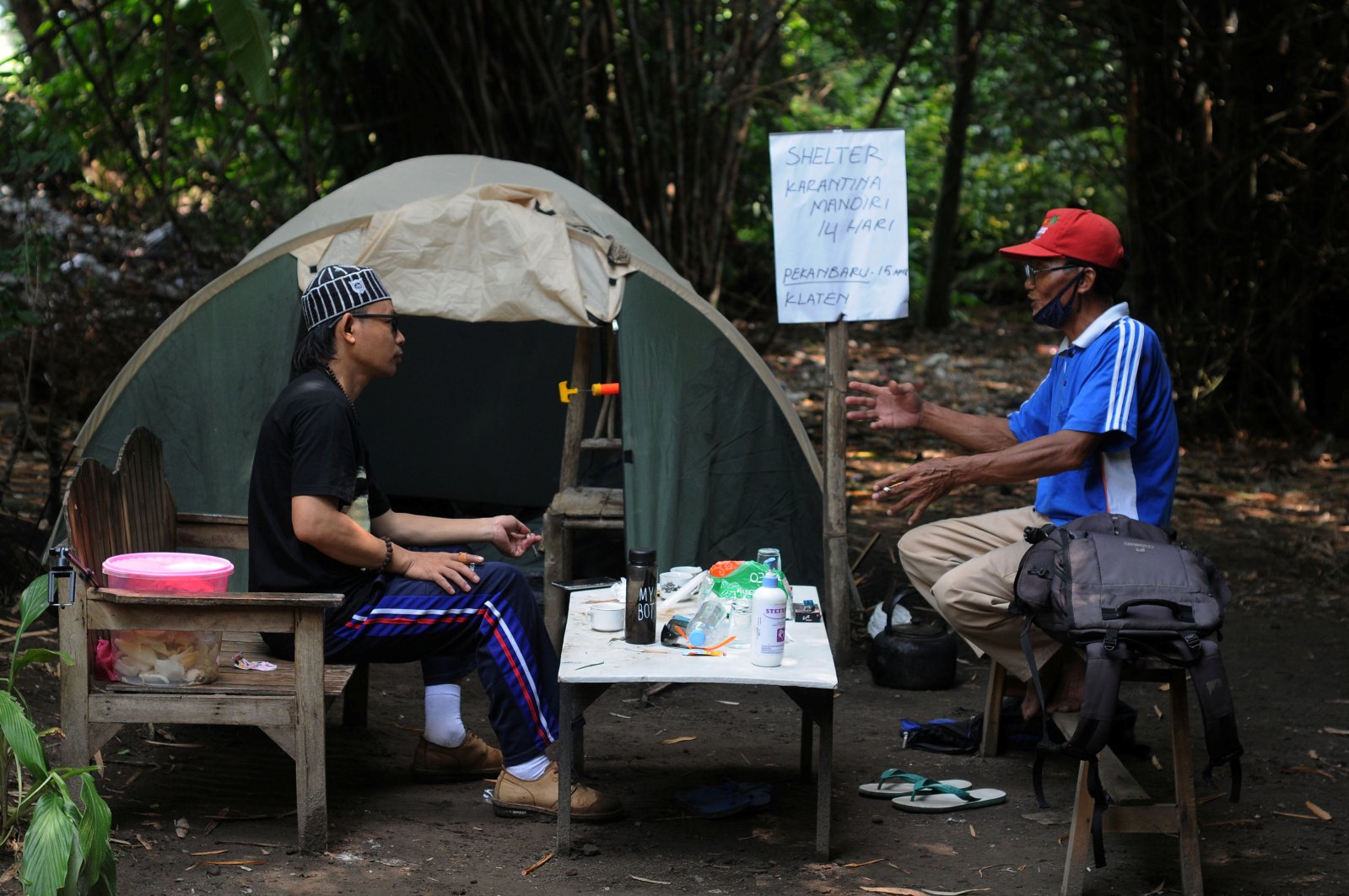 Abdullah Al Mabrur talks with his neighbour outside a tent he used for self-quarantine on a river bank after he came back from Pekanbaru, to prevent the spread of the coronavirus disease in Klaten, Central Java province, Indonesia, April 20, 2020. (Reuters Photo)