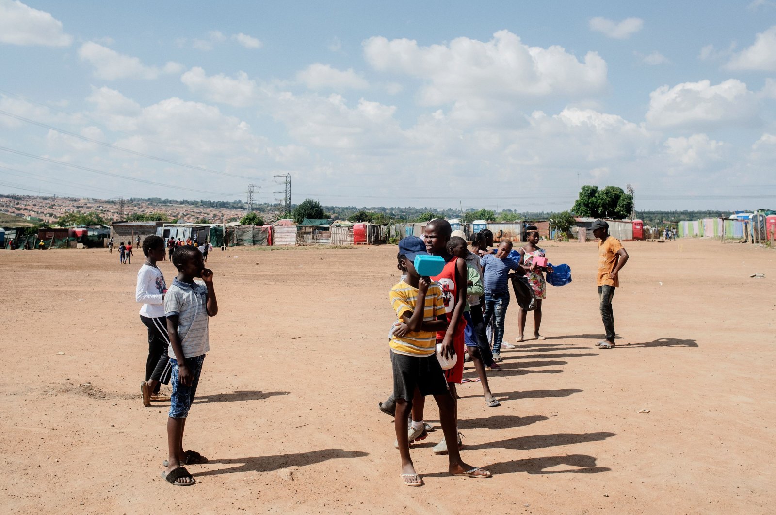 Children queue while they wait for the daily food distribution in the Tembisa informal settlement, Johannesburg on April 24, 2020. (AFP Photo)