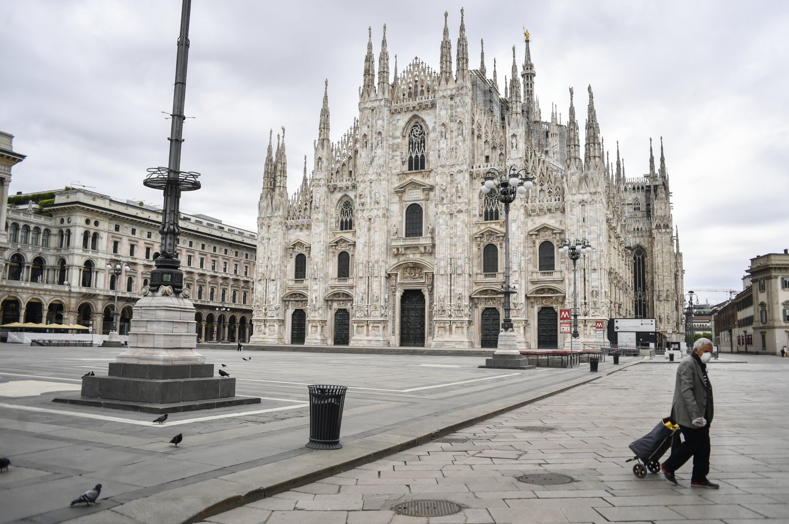 A man pulls his trolley past the Gothic cathedral in Milan during the coronavirus pandemic, Italy, April 27, 2020. (AP Photo)