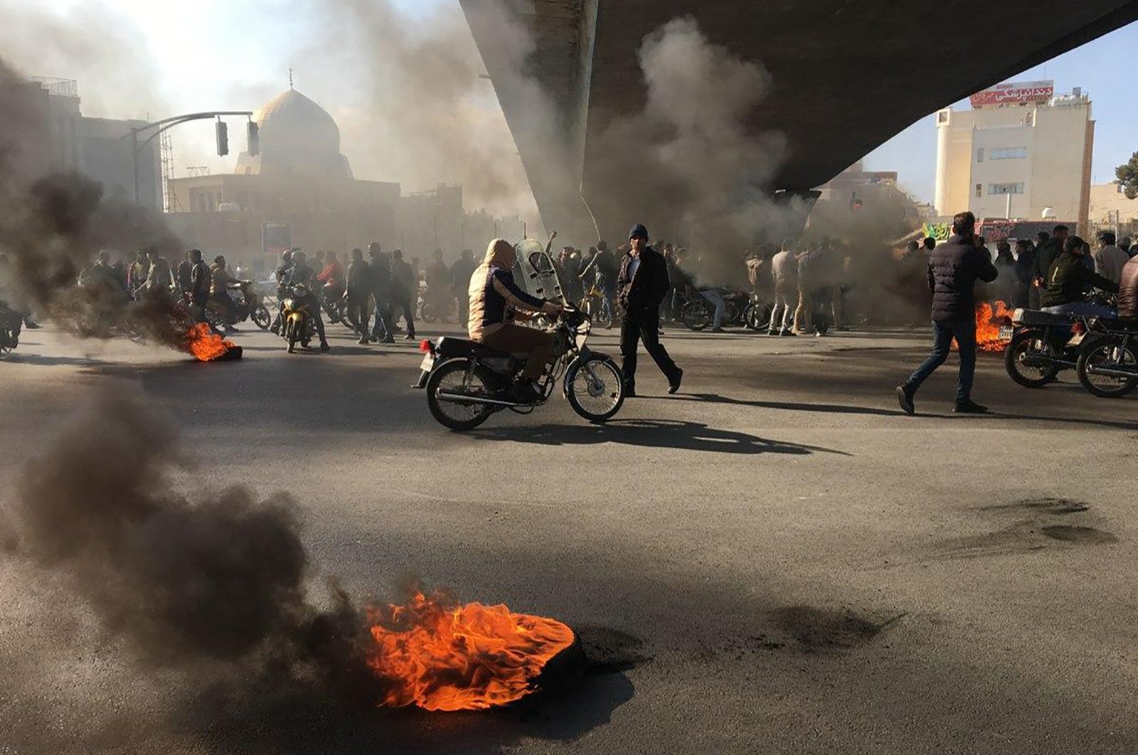 Iranian protesters rally amid burning tires during a demonstration against an increase in gasoline prices in the central city of Isfahan, Iran, Nov. 16, 2019. (AFP Photo)