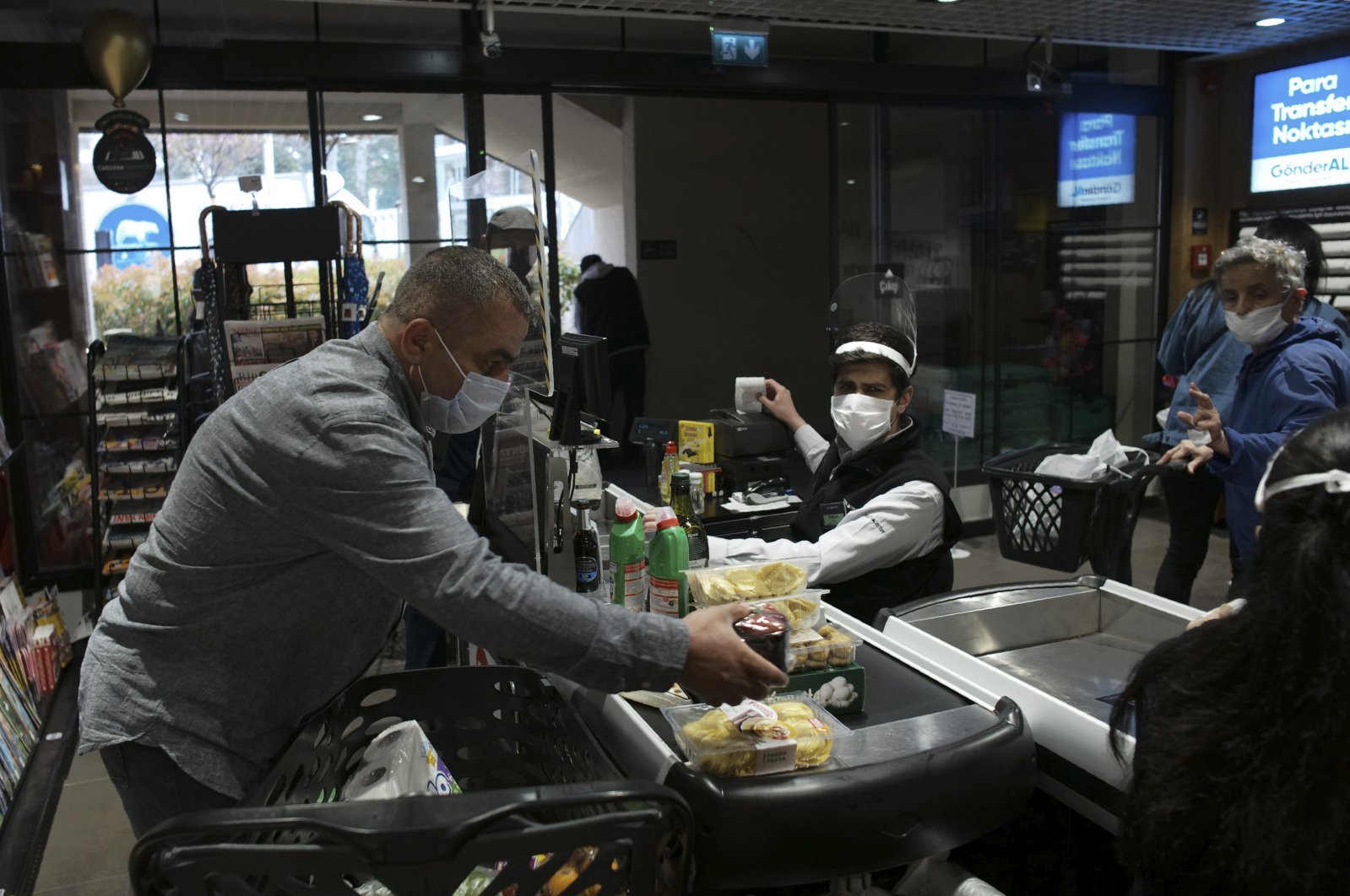 People wearing face masks shop for food at a grocery store during the coronavirus outbreak, Ankara, Turkey, April 21, 2020. (AP Photo)