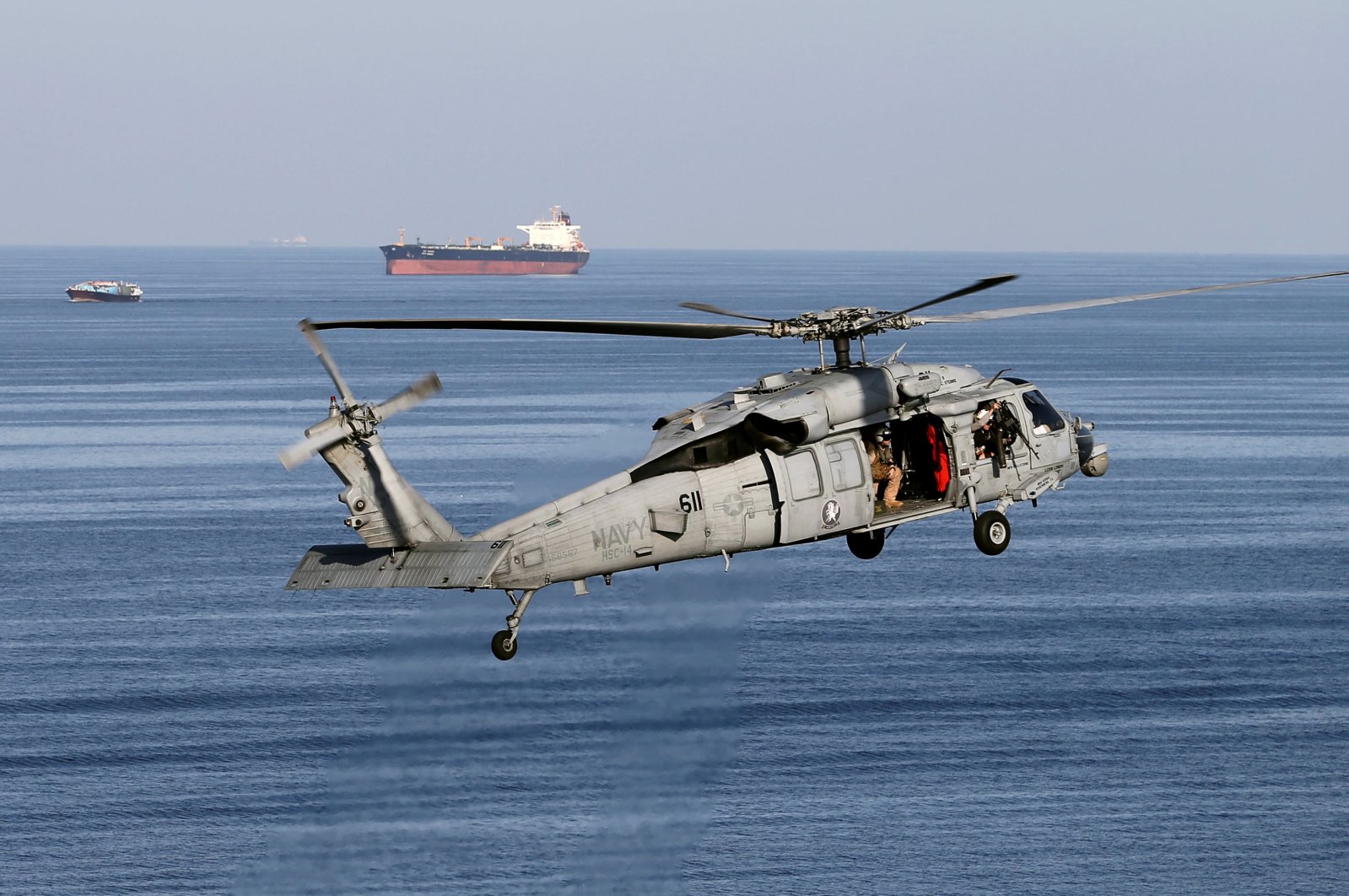 This file photo shows MH60S helicopter hovers in the air with an oil tanker in the background as the USS John C. Stennis makes its way to the Gulf through the Strait of Hormuz, Dec. 21, 2018. (Reuters Photo)