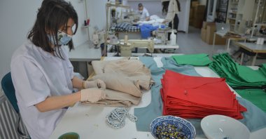 A worker puts small beads on scrubs at Aslı Filinta's workshop, in Istanbul, Turkey, April 30, 2020. (DHA Photo) 