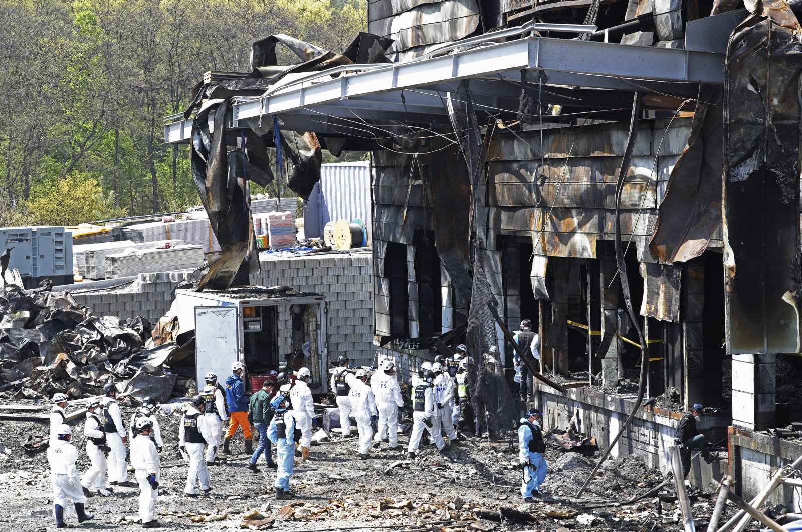 Police investigators enter to inspect a burnt construction site after a fire in Icheon, South Korea, Thursday, April 30, 2020. (AP Photo)