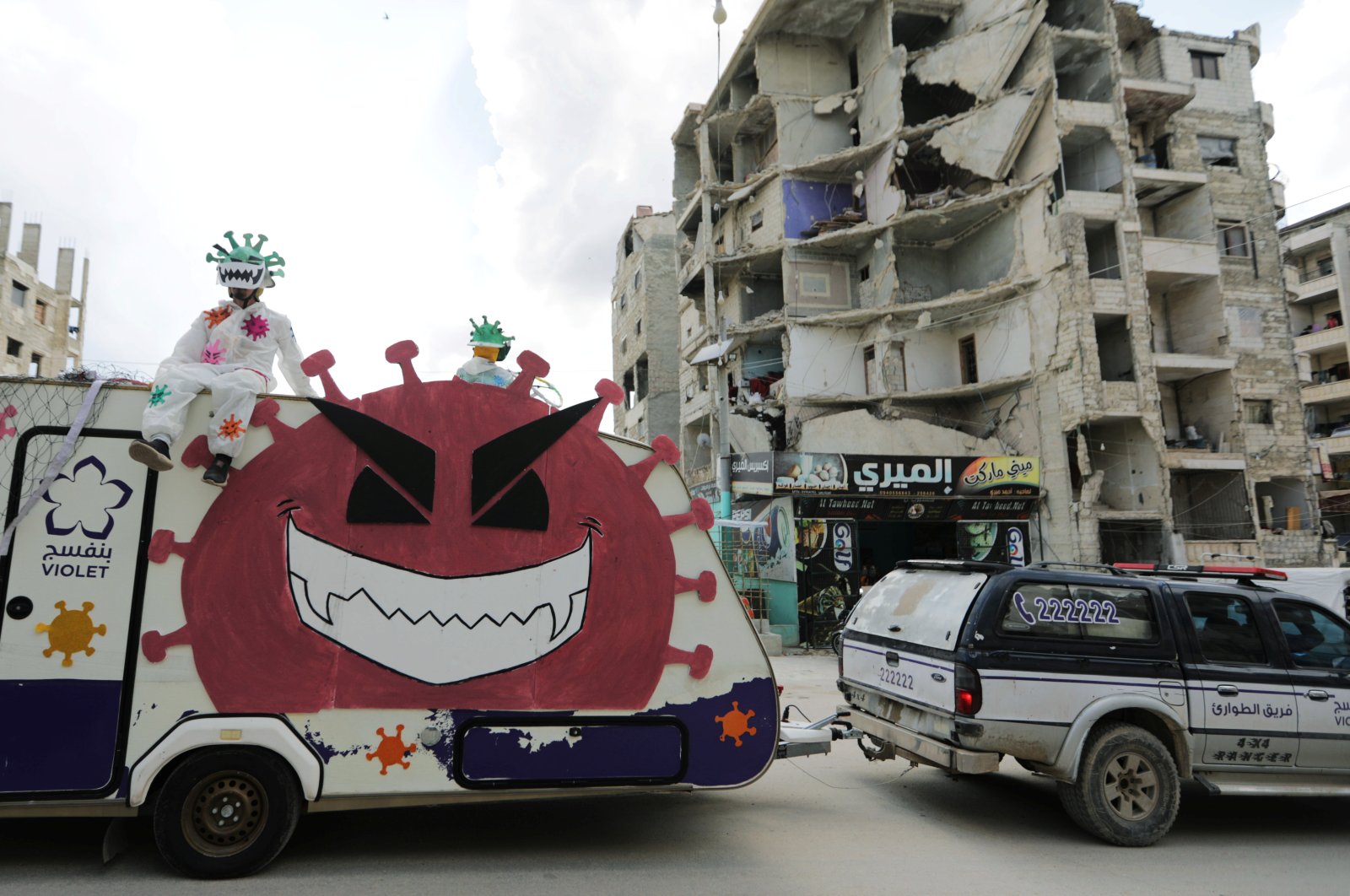 Volunteers dressed in coronavirus-themed costumes stand on a vehicle during a campaign organised by the Violet Organization, in an effort to spread awareness and encourage safety amid coronavirus disease (COVID-19) fears, in the opposition-held Idlib city, Syria, April 29, 2020. (REUTERS Photo)