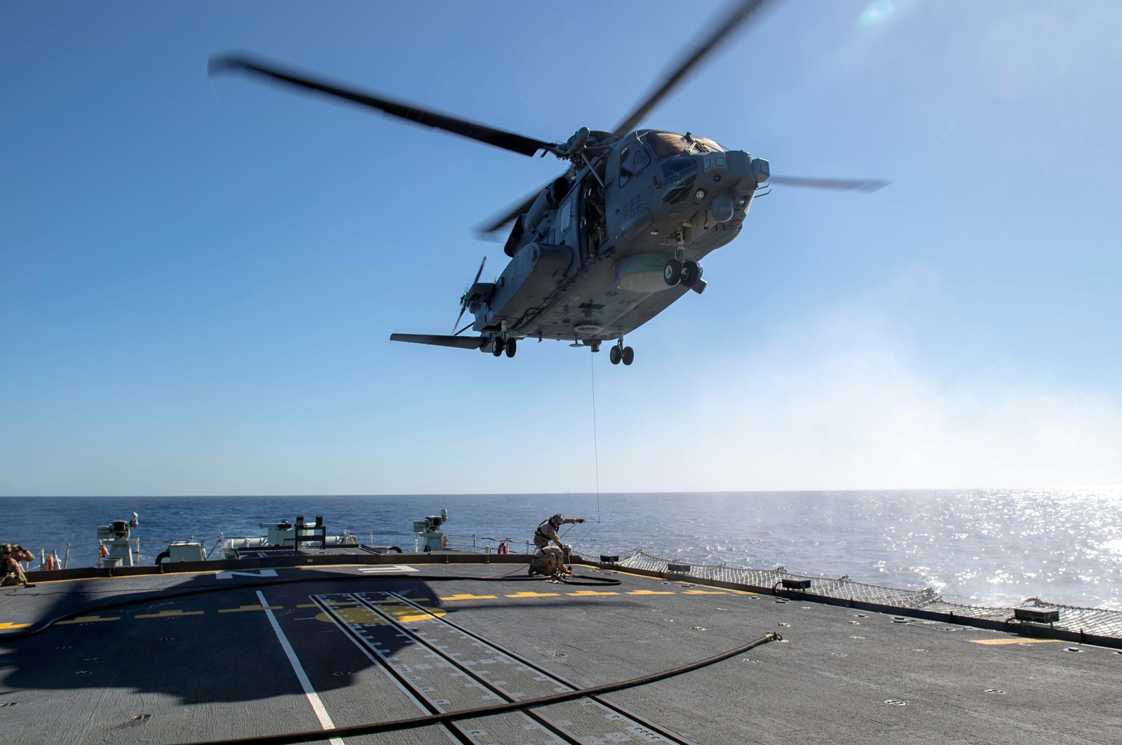 Air detachment members aboard HMCS Fredericton attach a fueling hose on the hoist cable of a CH-148 Cyclone helicopter during Operation Reassurance at sea Feb. 15, 2020, in this picture obtained from social media. (REUTERS Photo)