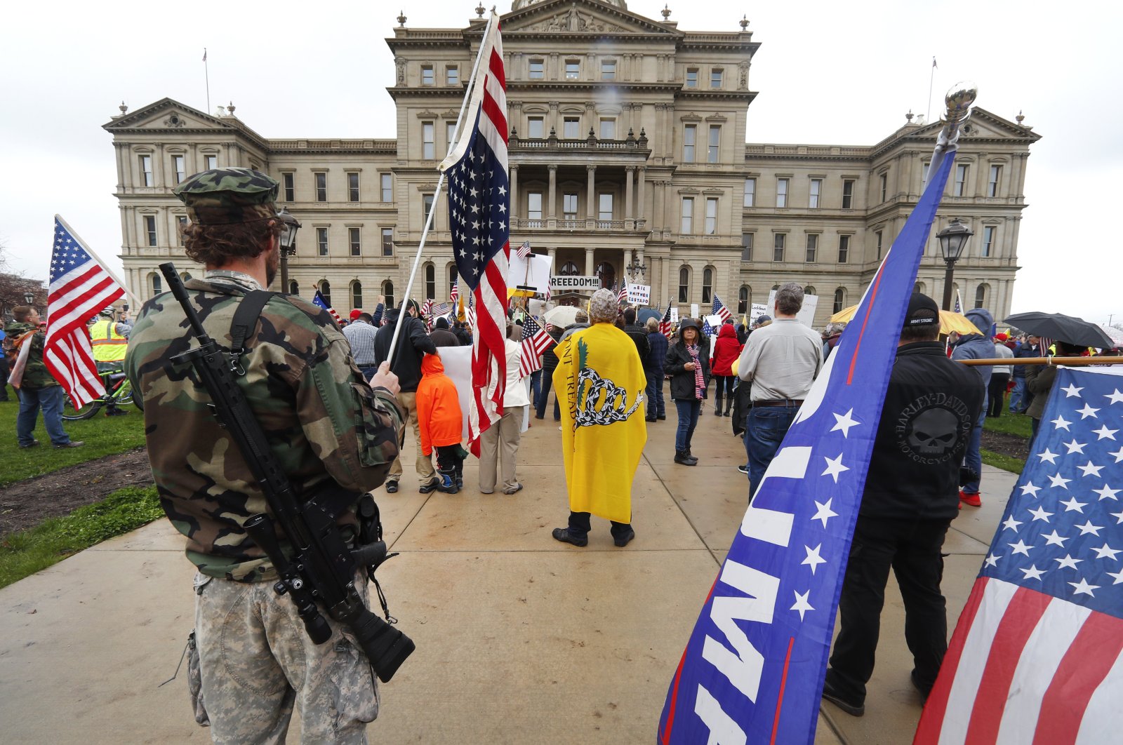 A protester carries his rifle at the State Capitol, Lansing, Mich., April 30, 2020. (AP Photo)