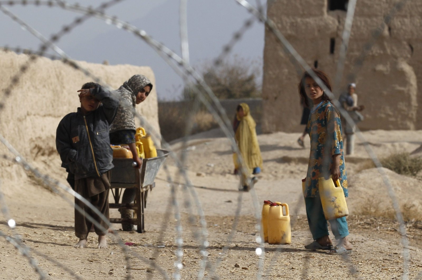 Afghan children look from behind a razor wire at an outpost in Zhari district, Kandahar Province, Nov. 20, 2010. (REUTERS Photo)