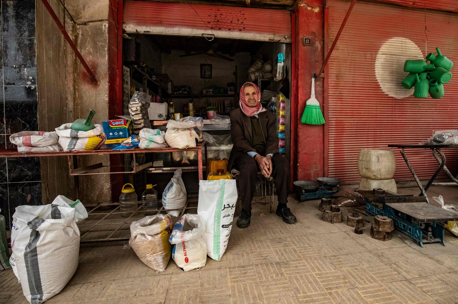 A Syrian man sits outside his store in the city of Qamishli in Syria's northeastern Hasakeh province, April 24, 2020. (AFP)