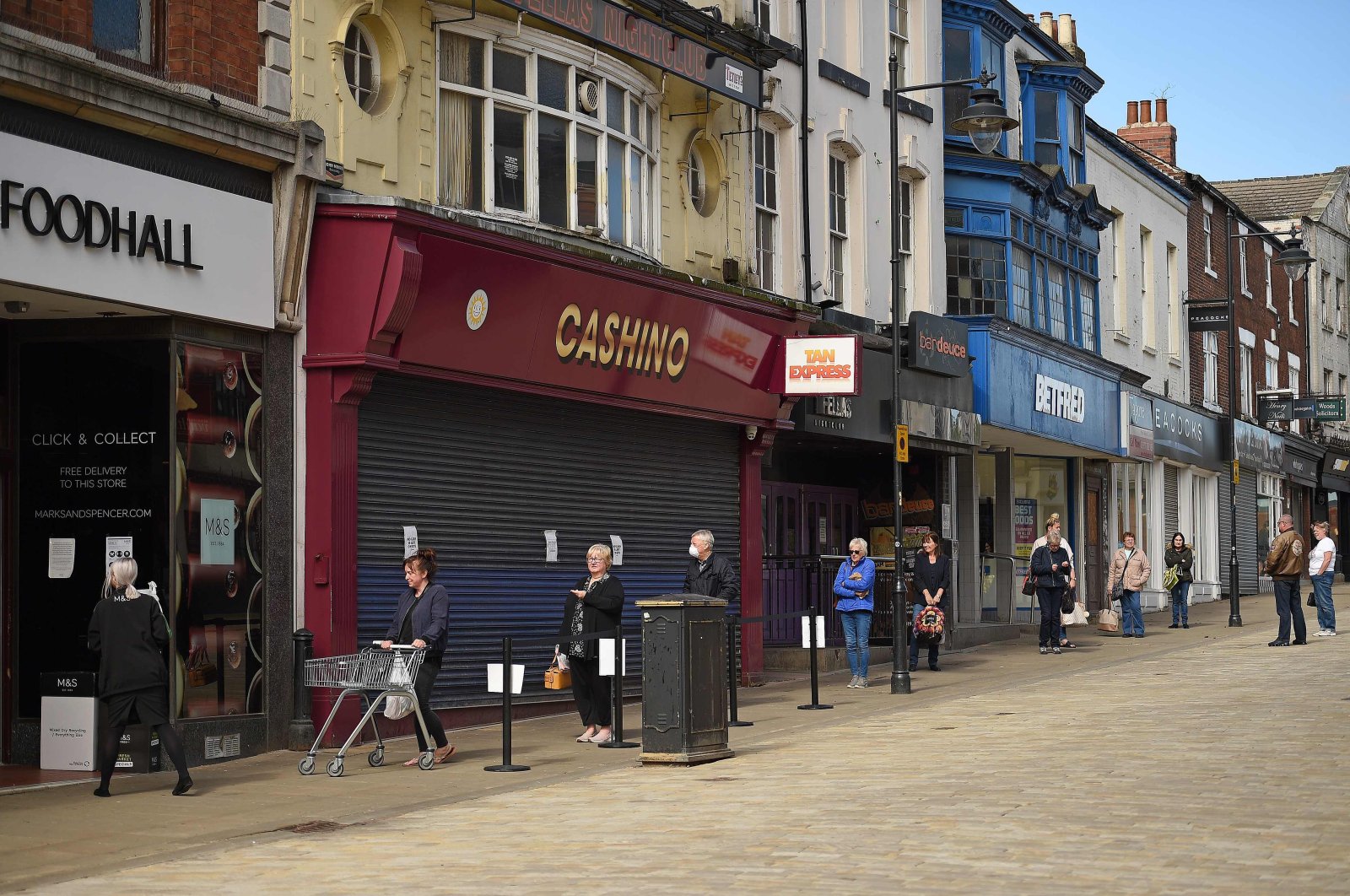 Shoppers observe social distancing guidelines as they line up to enter a Marks and Spencer food hall, Pontefract, April 27, 2020. (AFP Photo)