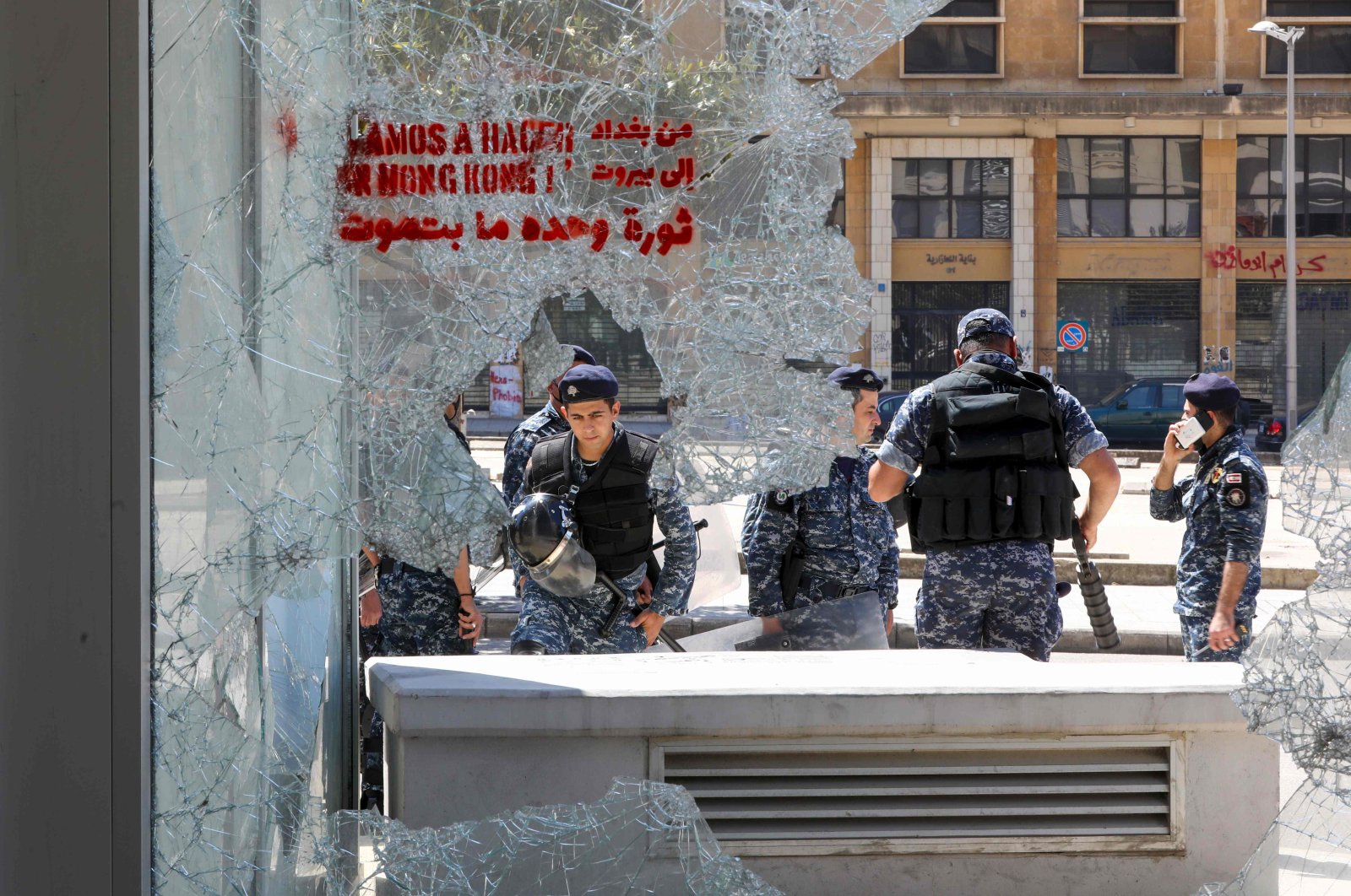 Members of the Lebanese security forces are seen through a broken store window in the downtown area of the capital Beirut, during an anti-government demonstration marking International Workers' Day (Labour Day), on May 1, 2020. (AFP Photo)