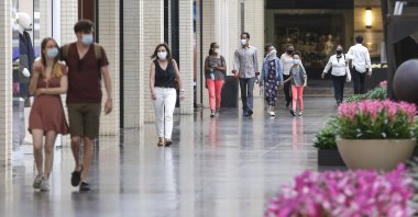 Shoppers walk through NorthPark Center mall on Friday, May 1, 2020 in Dallas, Texas. (The Dallas Morning News via AP)