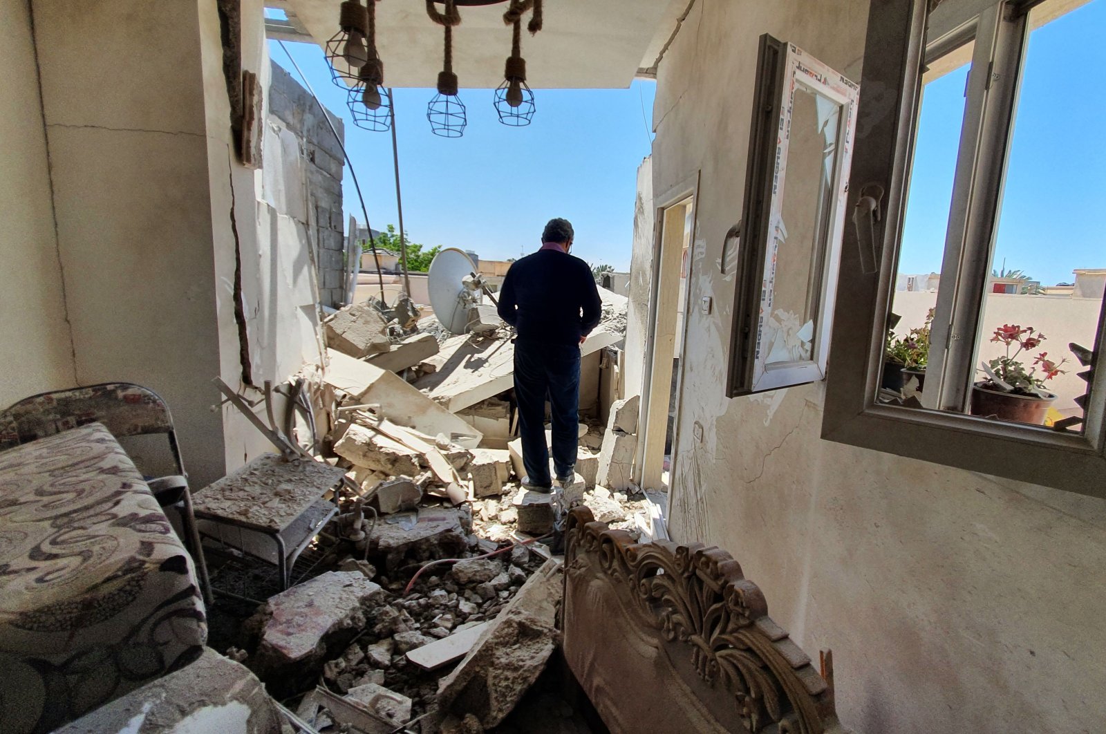 A resident walks amidst the rubble of a building that was damaged when forces loyal to putschist Gen. Khalifa Haftar shelled the residential neighborhood of Znatah in the Libyan capital Tripoli, held by the U.N.-recognized Government of National Accord (GNA), May 1, 2020. (AFP)
