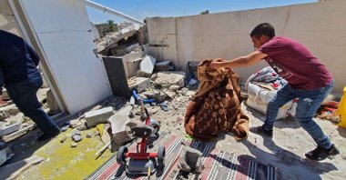 Residents salvage some belongings amidst the rubble of a building that was damaged when forces loyal to putschist Gen. Khalifa Haftar shelled the residential neighborhood of Znatah in the Libyan capital Tripoli,  May 1, 2020. (AFP)
