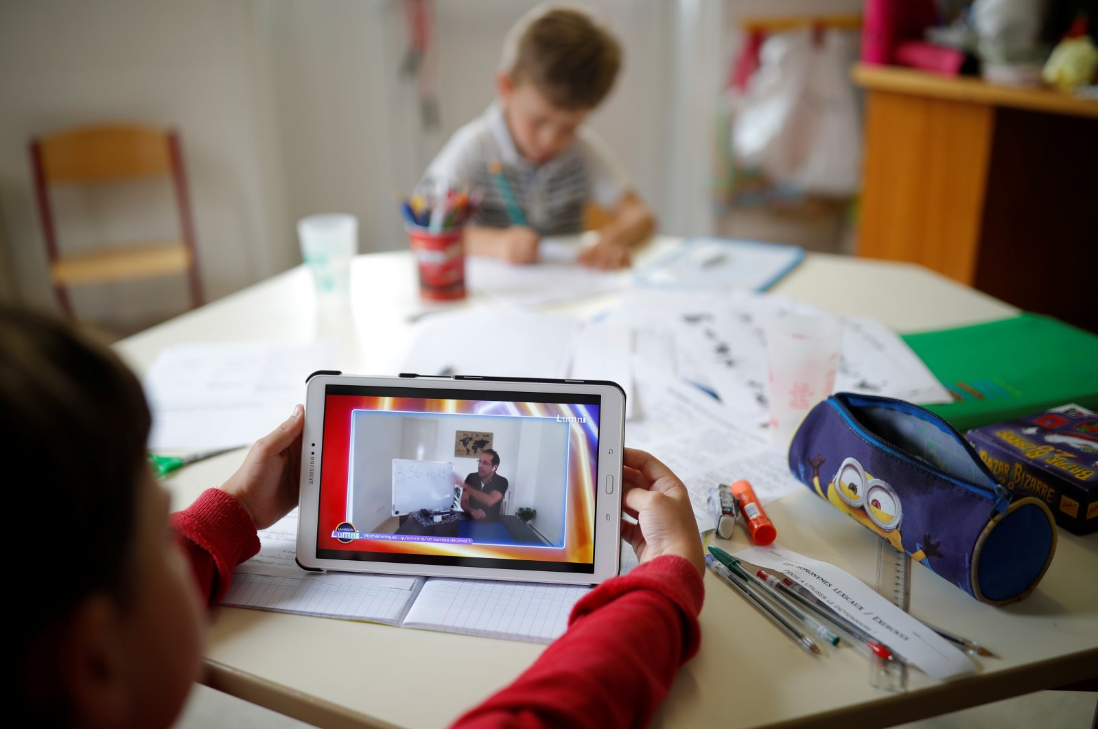 A pupil looks at a tablet to study with his teacher during an online school in a private school open to children of health workers and workers on the coronavirus frontline in Saint-Sebastien-sur-Loire near Nantes during the outbreak of the coronavirus disease (COVID-19) in France, May 4, 2020. (Reuters Photo) 