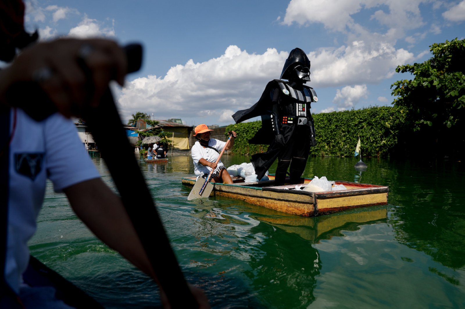 A village officer dressed as the Star Wars character Darth Vader rides a small boat to deliver relief goods to residents in the flooded Artex Compound in Malabon, Metro Manila, Philippines, May 4, 2020. REUTERS/Eloisa Lopez