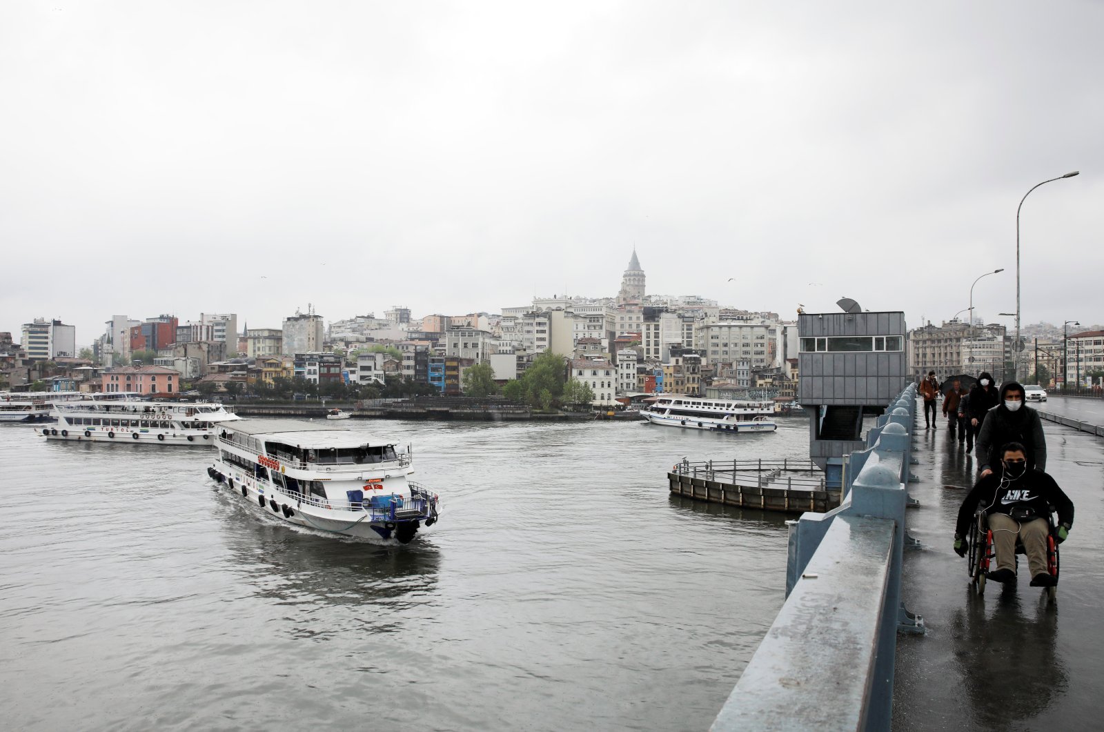 Boats sail along the Golden Horn and people walk on Galata Bridge, amid the coronavirus pandemic, in Istanbul, Turkey, May 4, 2020. (REUTERS Photo)