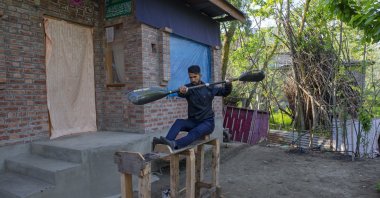 Kayaker Vilayat Hussain practices on a rugged under-construction wooden ergometer at his home, in Srinagar, Kashmir, April 24, 2020. (AP Photo) 