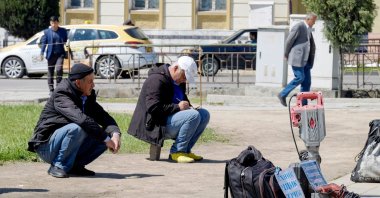 Unemployed men gather on the side of a road with the hope of landing odd jobs in Dushanbe, April 10, 2020. (AFP)