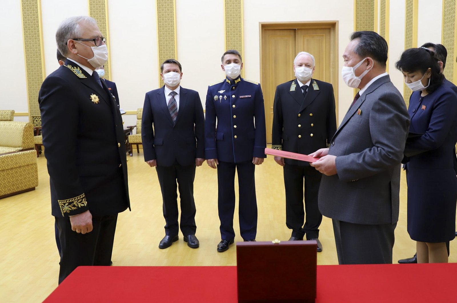 Russian Ambassador to the Democratic People's Republic of Korea Alexander Matsegora (L) and DPRK Foreign Minister Ri Son-gwon (R), both wearing face masks to protect against the novel coronavirus, attend a ceremony awarding North Korean leader Kim Jong-un with Russia's 75th anniversary Victory medal for his major contribution in commemorating Soviet soldiers, Pyongyang, North Korea, May 5, 2020. (AP Photo)