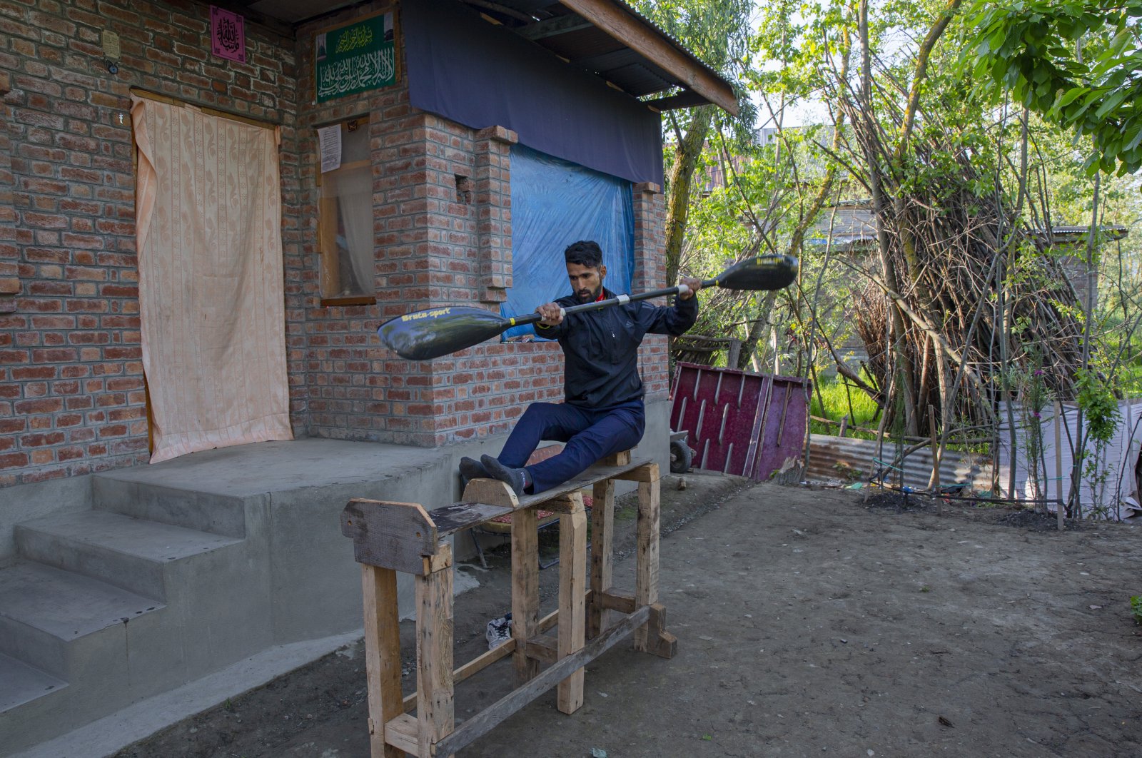 Kayaker Vilayat Hussain practices on a rugged under-construction wooden ergometer at his home, in Srinagar, Kashmir, April 24, 2020. (AP Photo) 