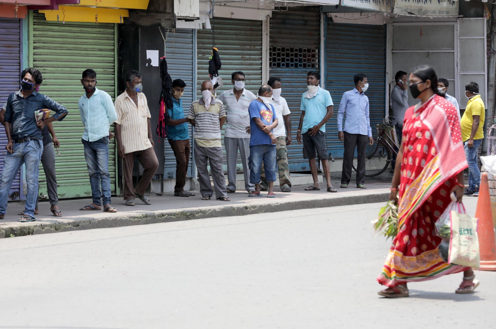 People wearing face masks queue up without keeping social distance outside a liquor store amid the ongoing coronavirus lockdown in Kolkata, India, May 5, 2020. (EPA Photo)