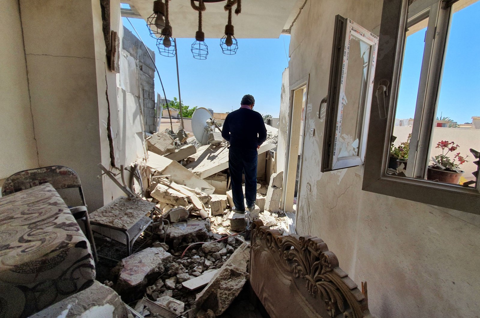  A resident walks amidst the rubble of a building that was damaged when putschist Gen. Khalifa Haftar's forces shelled the residential neighbourhood of Znatah in the Libyan capital Tripoli, held by the U.N.-recognized Government of National Accord (GNA), on May 1, 2020. (AFP Photo)