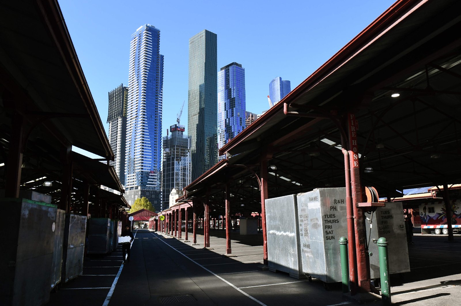 A man (L) walks through a deserted part of Melbourne's Queen Victoria Market, May 5, 2020. (AFP Photo)