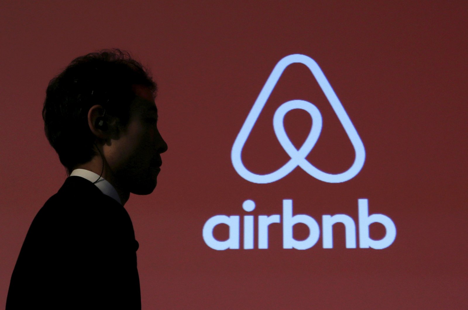 A man walks past a logo of Airbnb after a news conference in Tokyo, Japan, Nov. 26, 2015. (REUTERS)