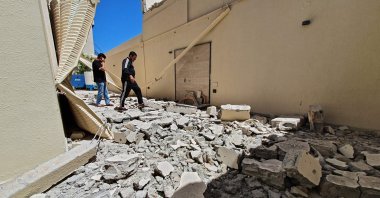 Residents walk amid the rubble of a building damaged when forces loyal to eastern-based warlord Khalifa Haftar shelled the residential neighborhood of Znatah in the Libyan capital Tripoli, held by the U.N.recognized Government of National Accord (GNA), May 1, 2020. (AFP Photo)