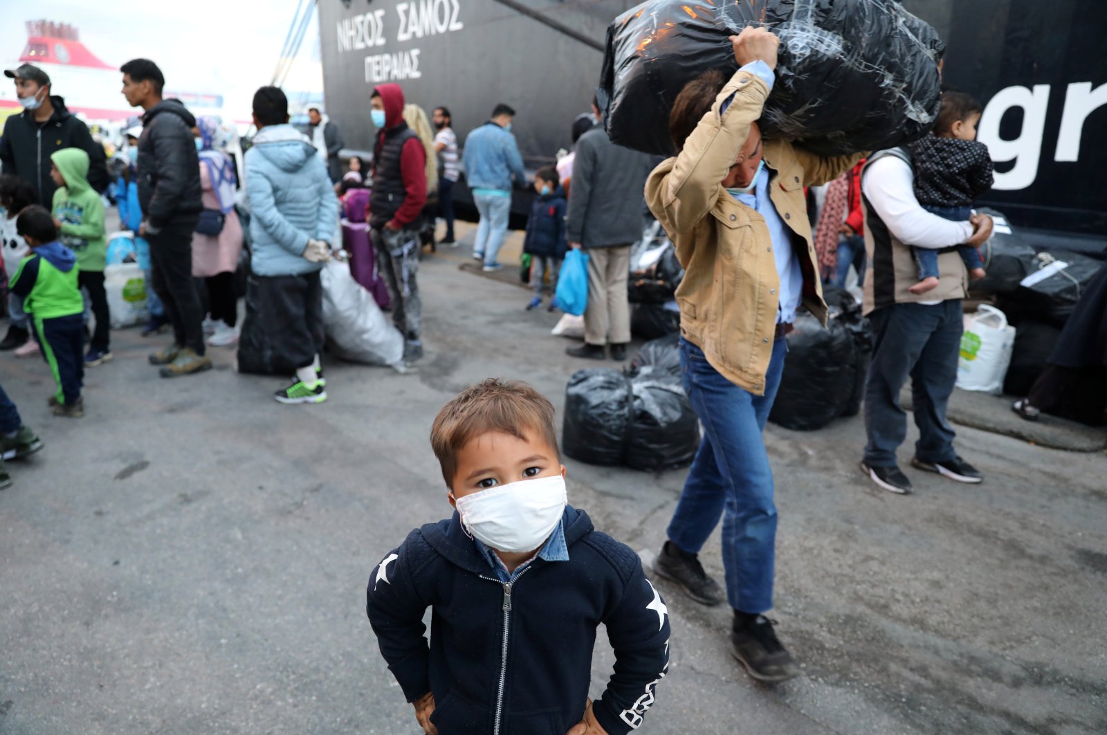 A migrant boy from the Moria camp in Lesbos waits to board a bus at Piraeus port in Athens following the coronavirus disease (COVID-19) outbreak, Greece, May 4, 2020. (Reuters Photo)
