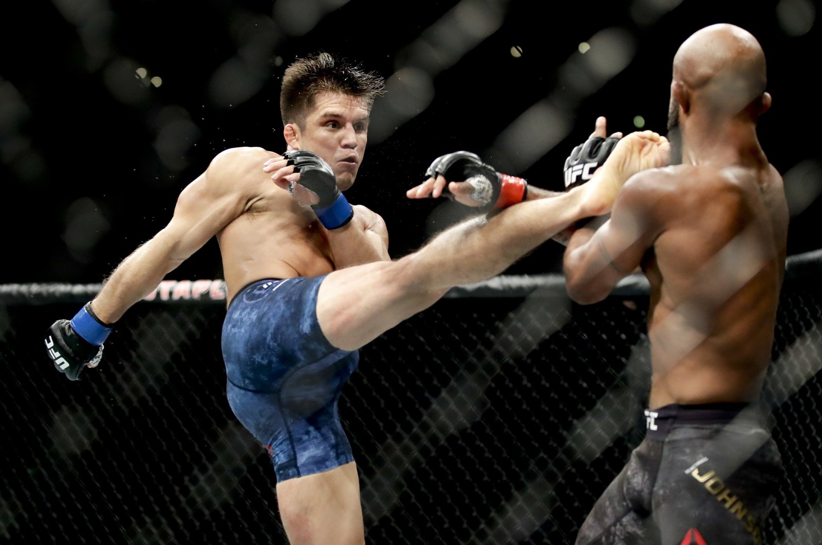 Henry Cejudo kicks Demetrious Johnson during their UFC flyweight title mixed martial arts bout at UFC 227 in Los Angeles, Aug. 4, 2018. (AP Photo)