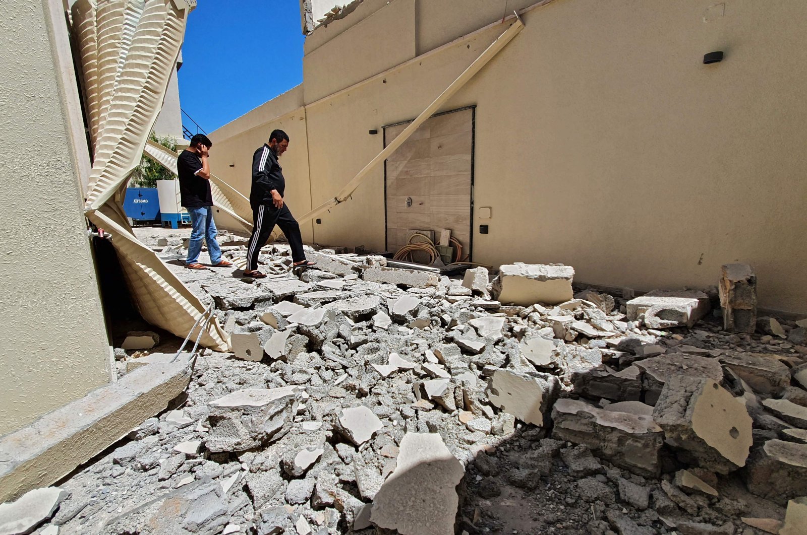 Residents walk amid the rubble of a building damaged when forces loyal to eastern-based warlord Khalifa Haftar shelled the residential neighborhood of Znatah in the Libyan capital Tripoli, held by the U.N.recognized Government of National Accord (GNA), May 1, 2020. (AFP Photo)