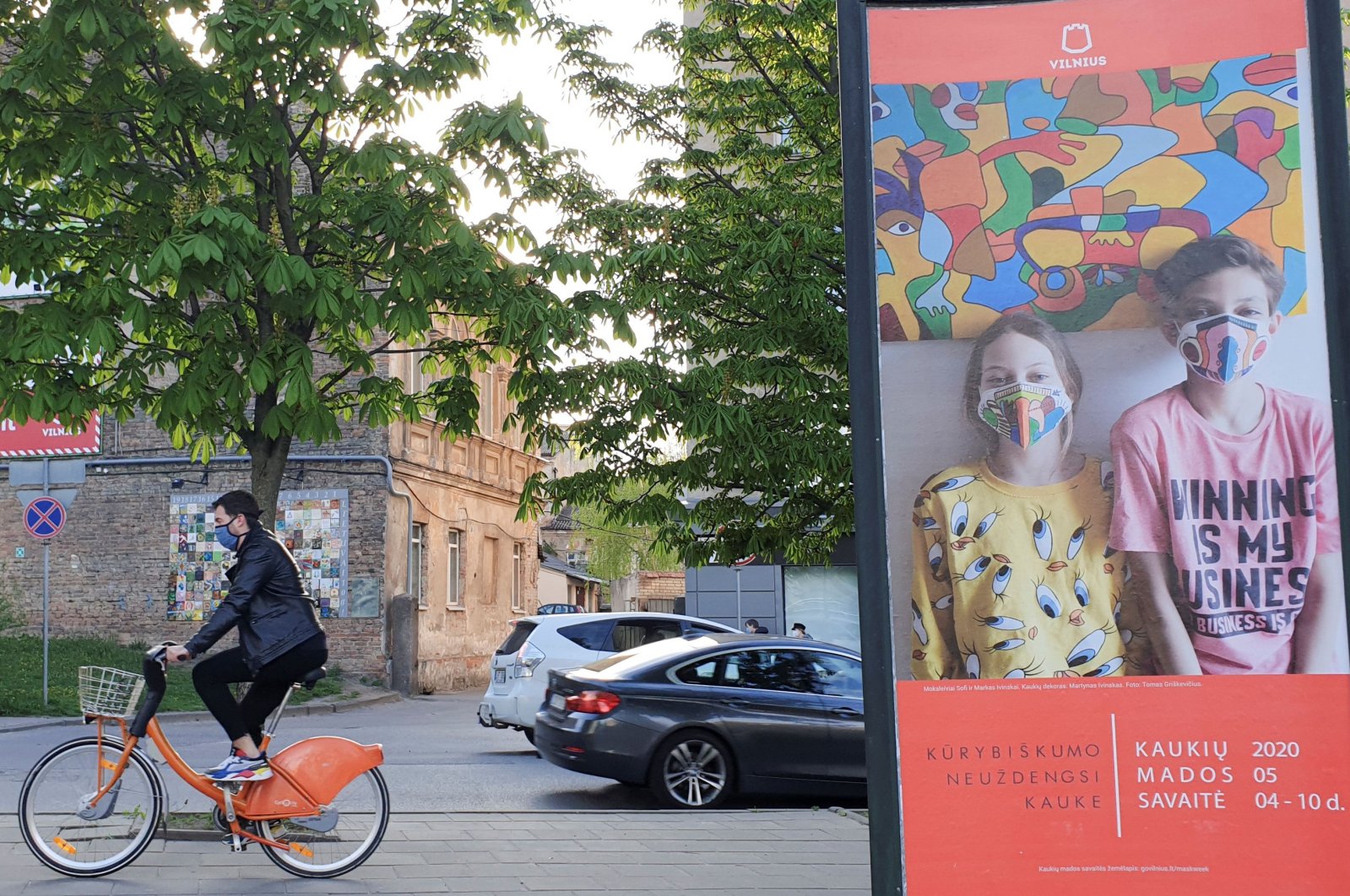 A bicyclist rides next to a billboard for "Mask Fashion Week" during the coronavirus outbreak in Vilnius, Lithuania, May 5, 2020. (Reuters Photo)