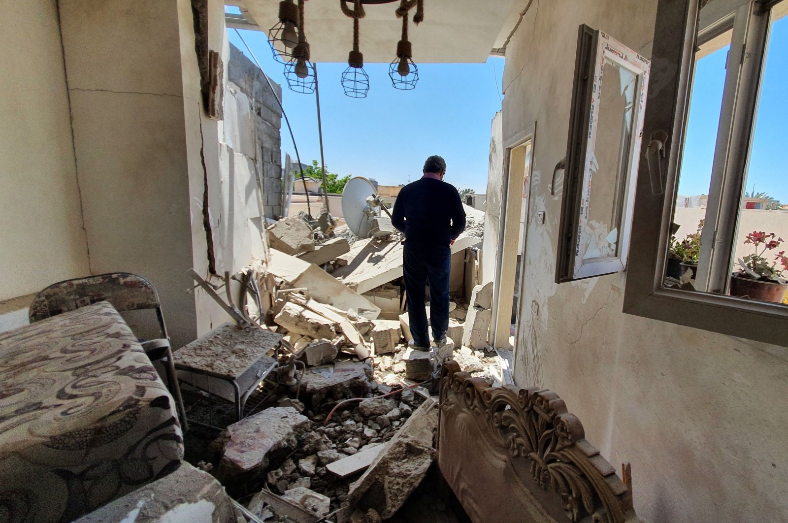 A resident walks amidst the rubble of a building that was damaged when forces loyal to eastern-based putschist Gen. Khalifa Haftar shelled the residential neighbourhood of Znatah in the Libyan capital Tripoli, May 1, 2020. (AFP Photo)