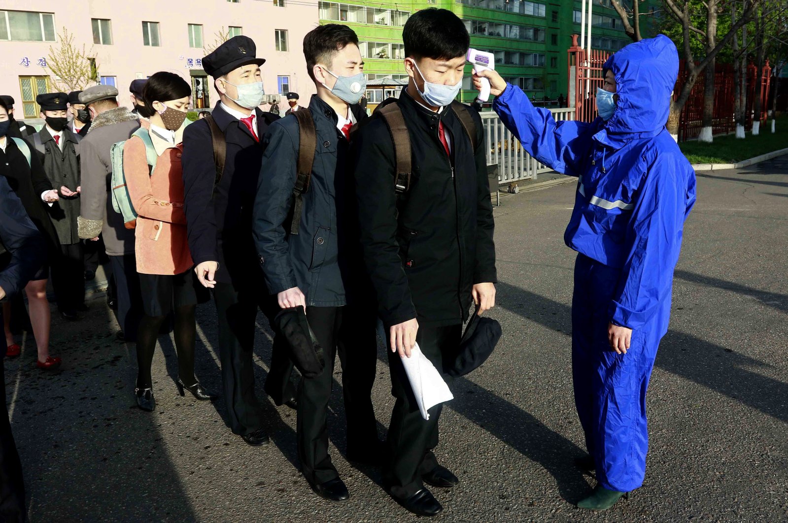 Students wearing face masks have their temperature checked as a precaution against the new coronavirus before returning to classes at Kim Chaek University of Technology, Pyongyang, North Korea, April 22, 2020. (AP Photo)