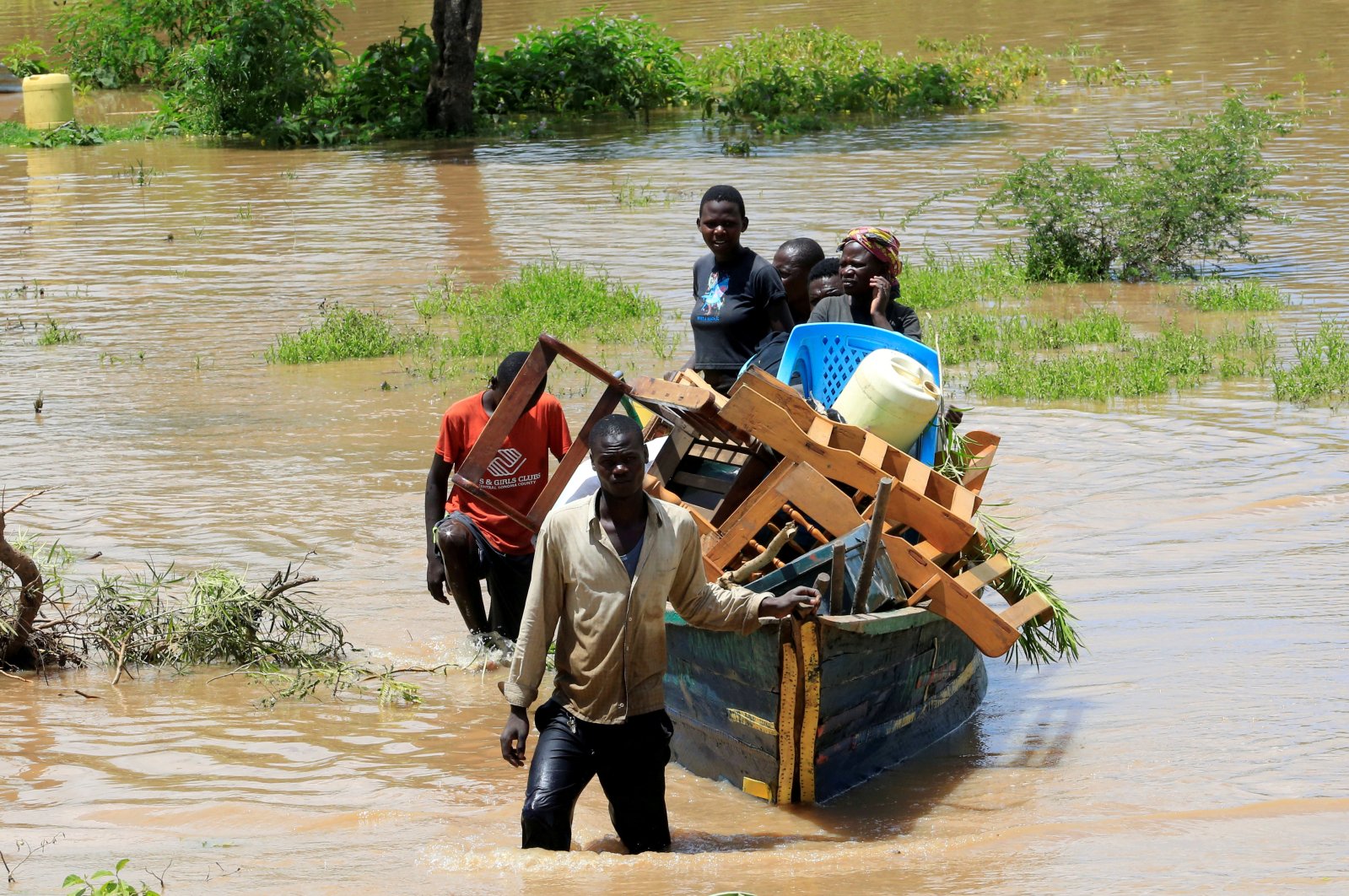 Residents use a boat to carry their belongings through the waters after their homes were flooded in Budalangi, in Busia County, Kenya, May 3, 2020. (Reuters Photo)