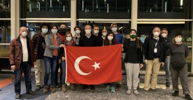 Evacuated Turkish nationals pose with a Turkish flag at an airport in Buenos Aires, Argentina, May 6, 2020. (AA Photo) 