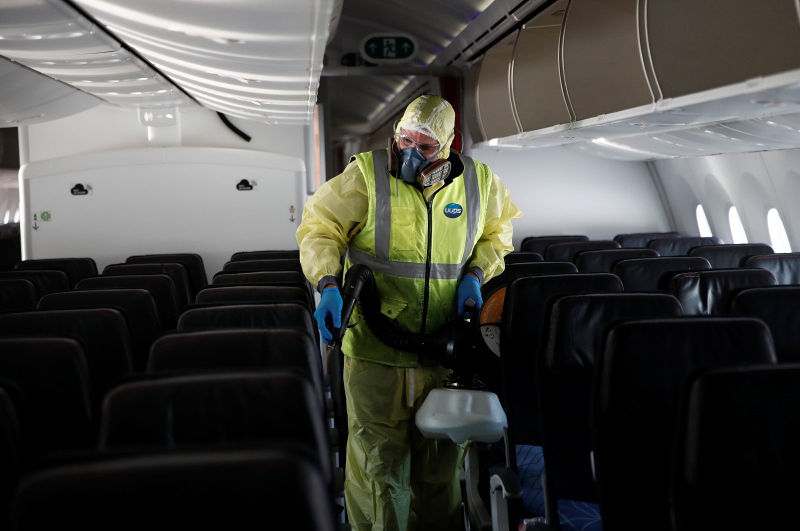 A worker, wearing a protective suit, sprays disinfectant inside an Air France Boeing 787 aircraft during a presentation of new security and health measures at Paris Charles de Gaulle airport in Roissy-en-France during the outbreak of the coronavirus in France, May 6, 2020. (Reuters Photo)