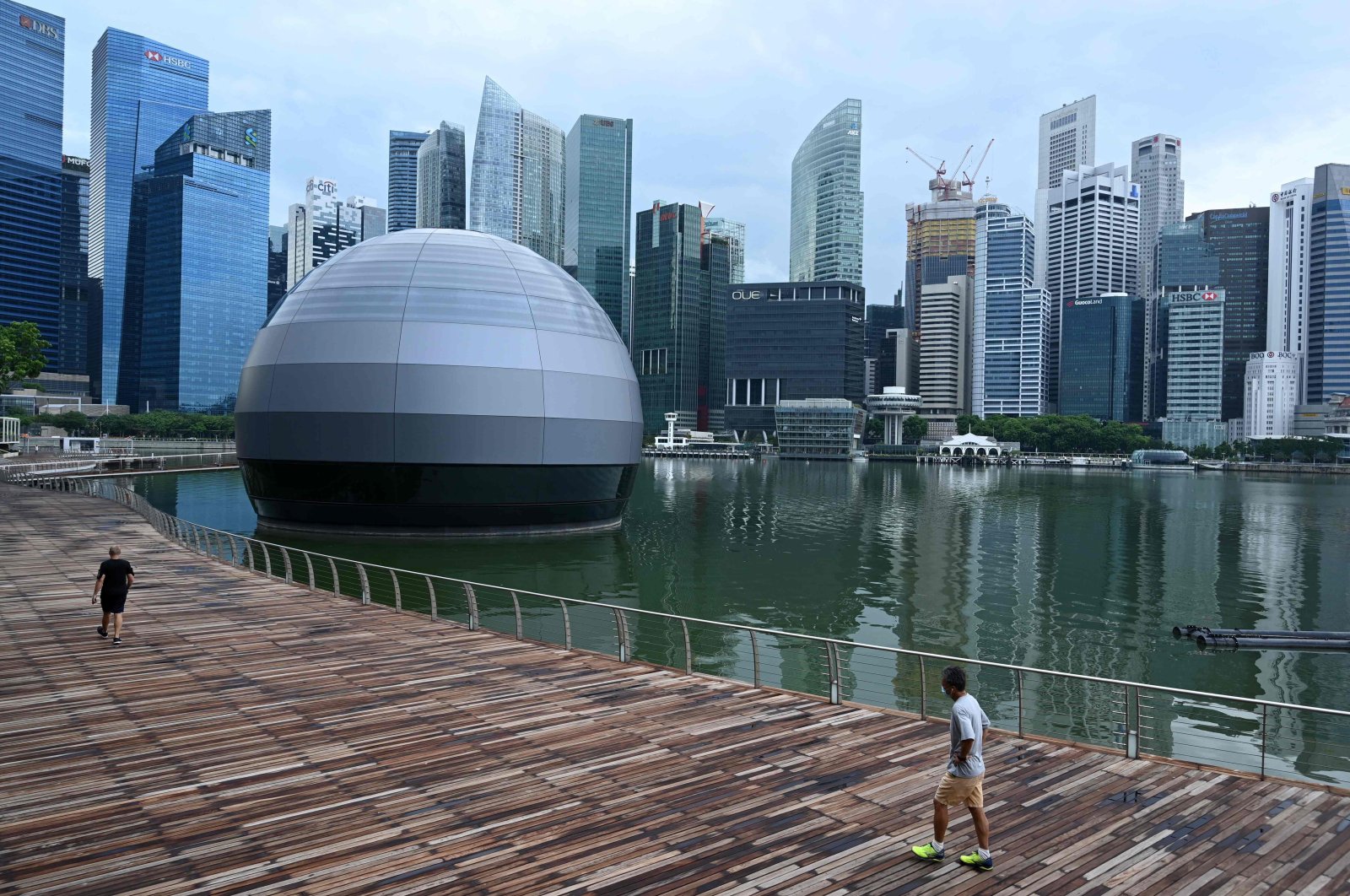 People wearing face masks as a preventive measure against the spread of the COVID-19 outbreak walk along the promenade at Marina Bay in Singapore, May 4, 2020. (AFP Photo)