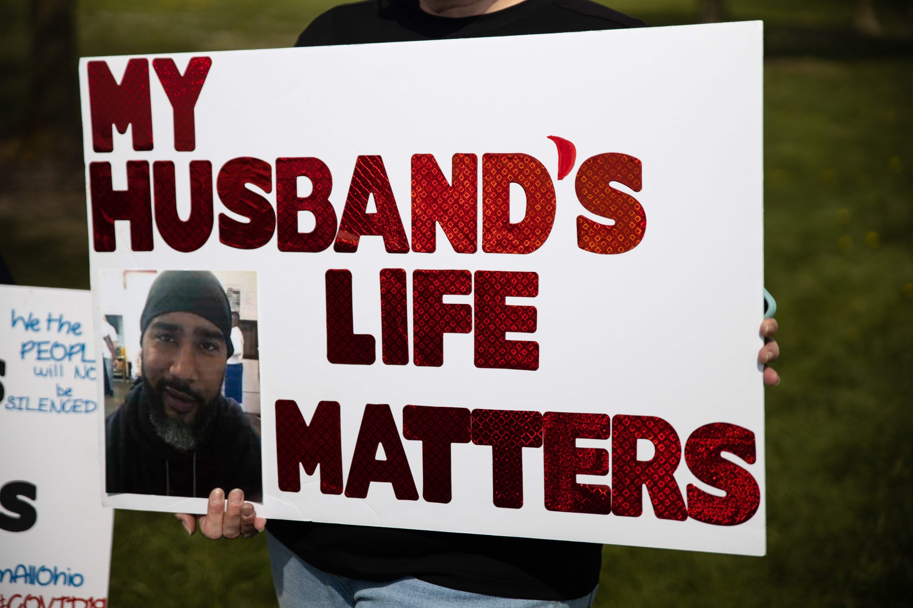 A woman holds a sign of her husband, an inmate at Marion Correctional Institution, at a protest to raise awareness of the high risk of COVID-19 infection inside the prison in Marion, Ohio, May 2, 2020. (AFP Photo)
