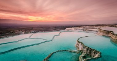 The natural pools created by the carbonate travertines are spectacular during sunset. (iStock Photo)