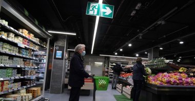 A man wearing a protective mask queues up to buy vegetables in a supermarket in Nantes, France, May 4, 2020. (AFP Photo)