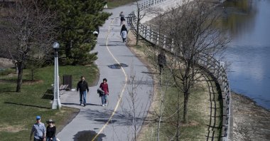 People walking along the Rideau Canal Western Pathway take advantage of warm weather in the midst of the COVID-19 pandemic, in Ottawa on May 3, 2020. (AP Photo)