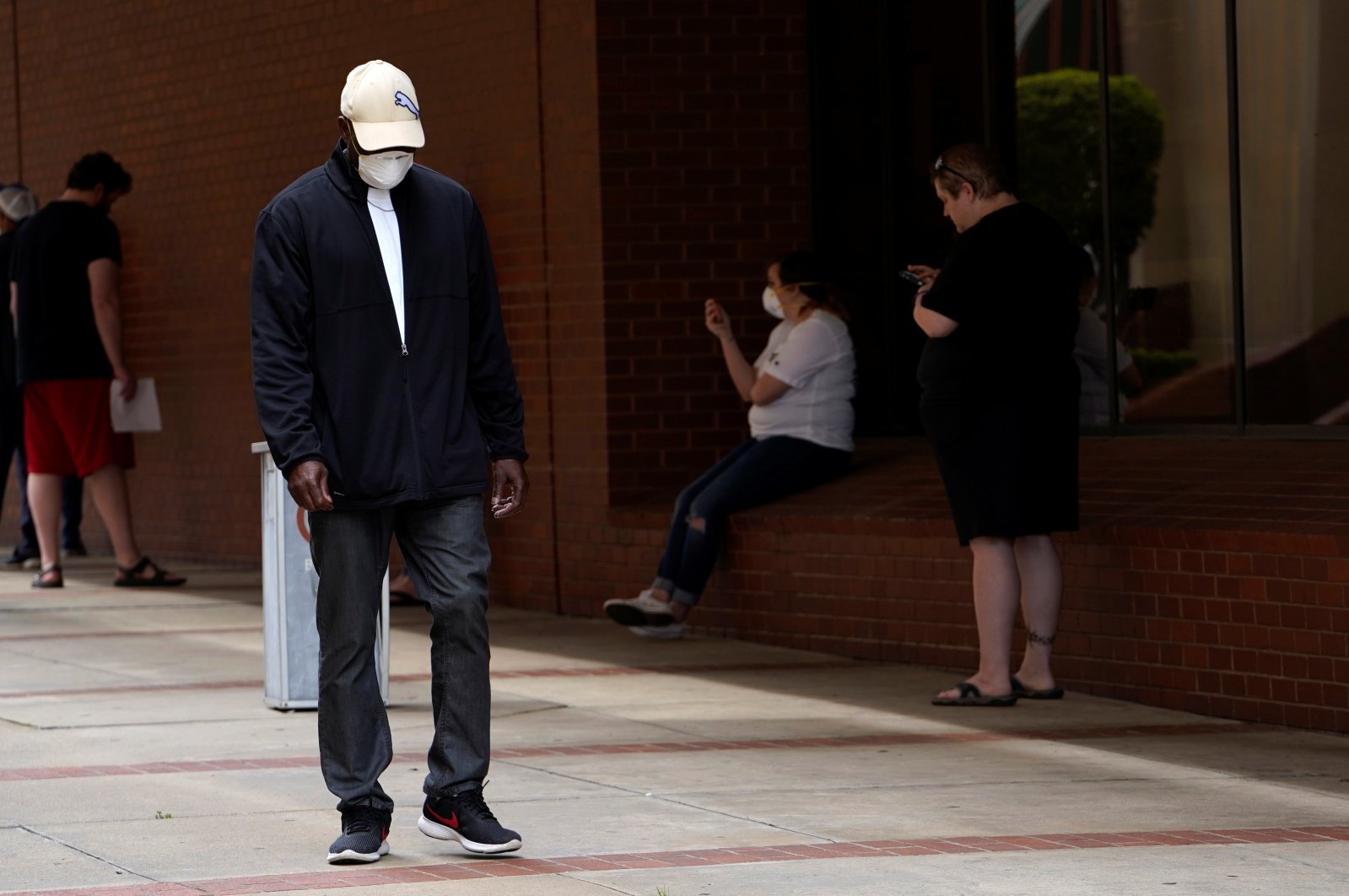 A man who lost his job walks past others as they wait in line to file for unemployment during the coronavirus pandemic, at an Arkansas Workforce Center in Fort Smith, Arkansas, U.S., April 6, 2020. (Reuters Photo)