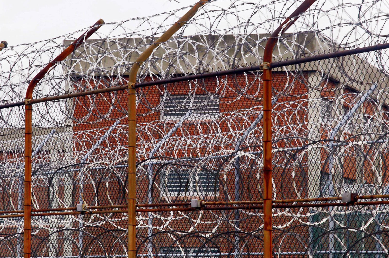 In this March 16, 2011, file photo, a security fence surrounds inmate housing at the Rikers Island correctional facility in New York. As of May 6, 2020, more than 20,000 inmates have been infected by the coronavirus and 295 have died nationwide, according to an unofficial tally kept by UCLA Law's COVID-19 Behind Bars Data Project. (AP File Photo)