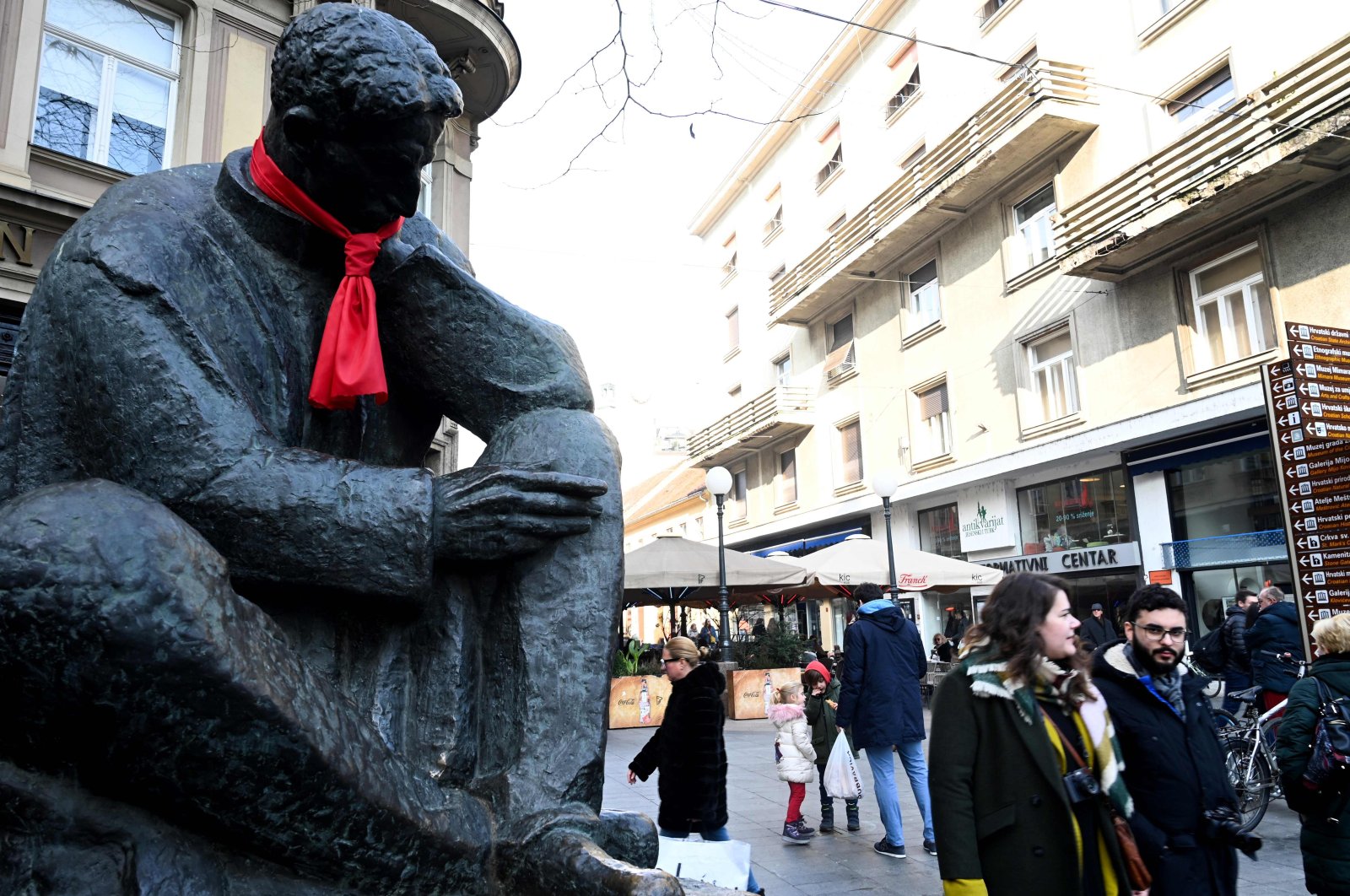 People walk past a statue of Nikola Tesla, one of the pioneers of modern electrical engineering, with a red tie knotted around the neck symbolizing Croatia's taking over the EU's rotating presidency of the EU Council, in central Zagreb, Jan. 3, 2020. (AFP Photo)
