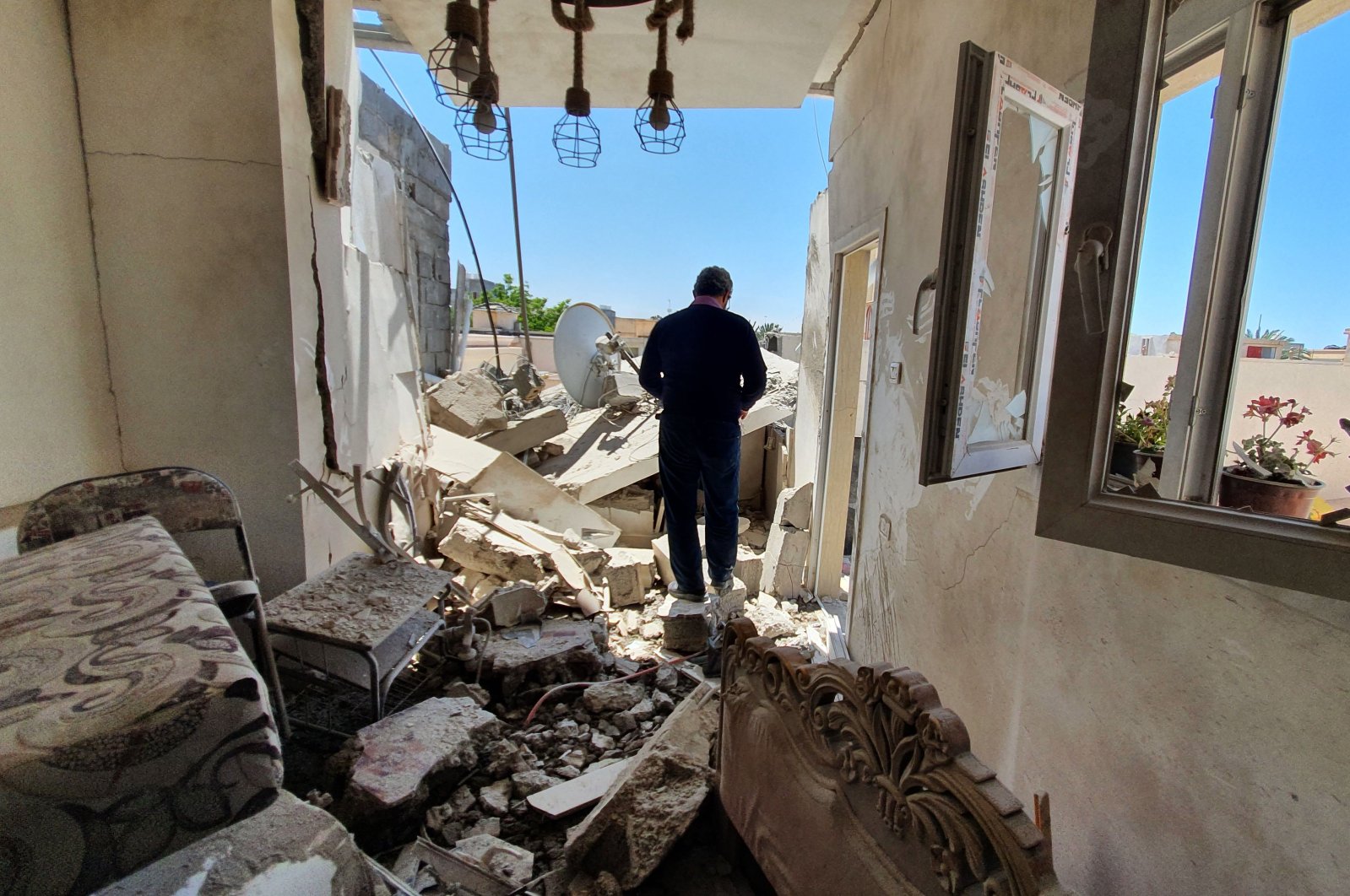 A resident walks amidst the rubble of a building that was damaged when forces loyal to eastern-based putschist Gen. Khalifa Haftar shelled the residential neighbourhood of Znatah in the Libyan capital Tripoli, May 1, 2020. (AFP Photo)